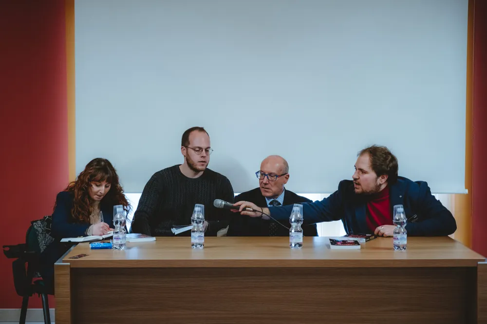 Quattro relatori al tavolo durante la presentazione del romanzo